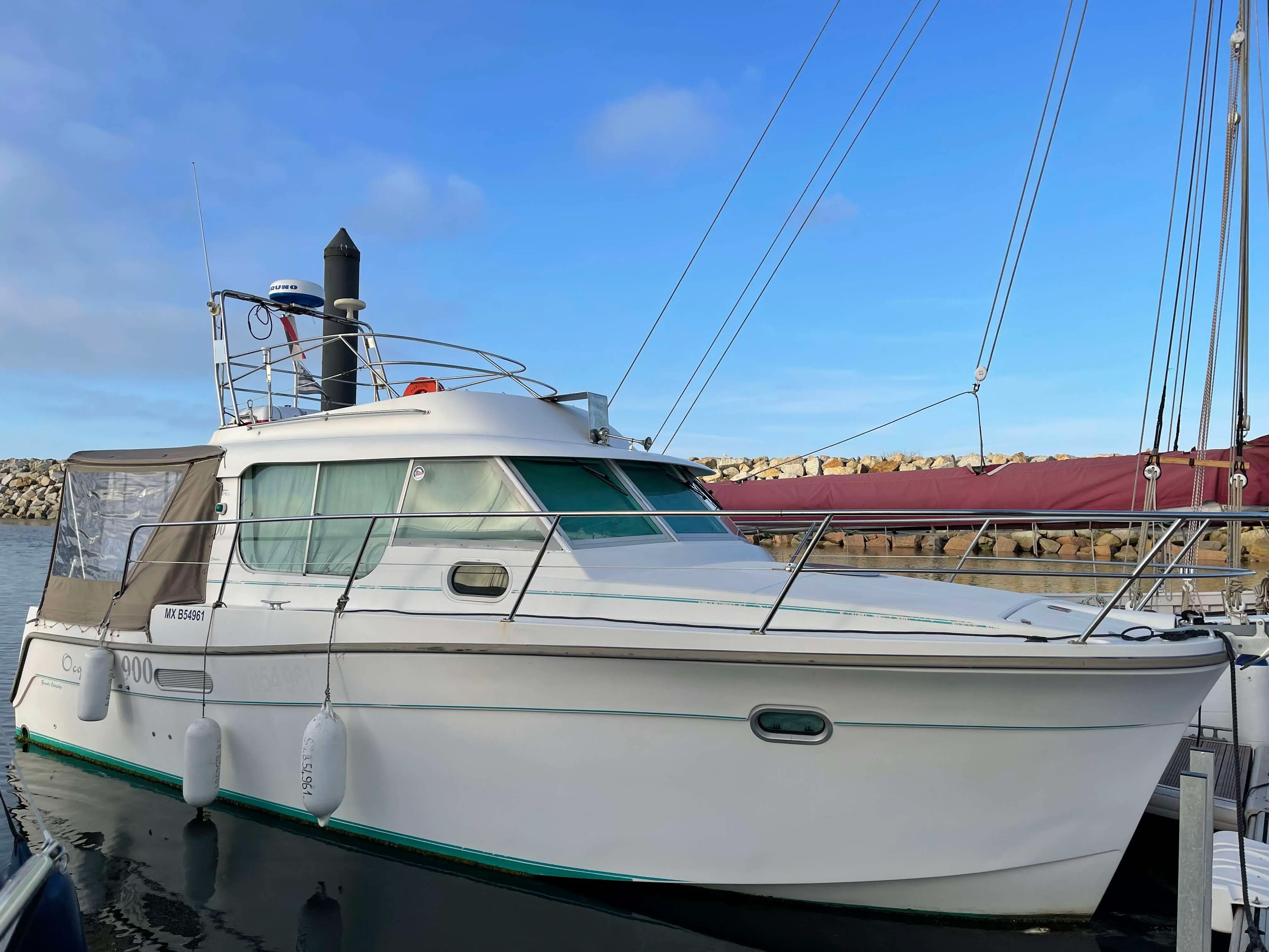 Ocqueteau 900 — Bateau à moteur blanc amarré dans un port, vu de trois quarts bâbord.