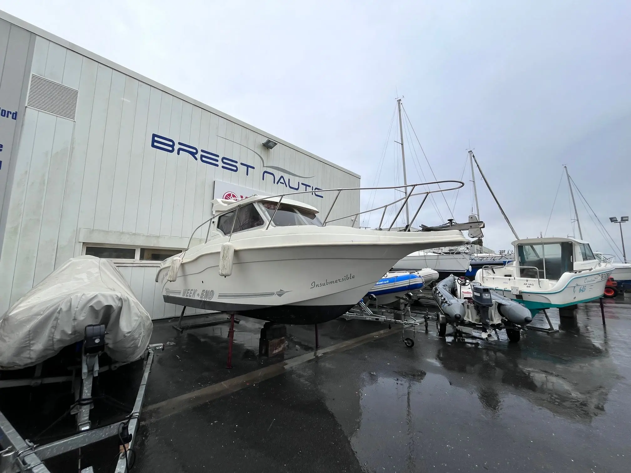 Ultramar 700 Week End — Bateau à moteur blanc photographié sur ber dans une zone de stockage nautique.