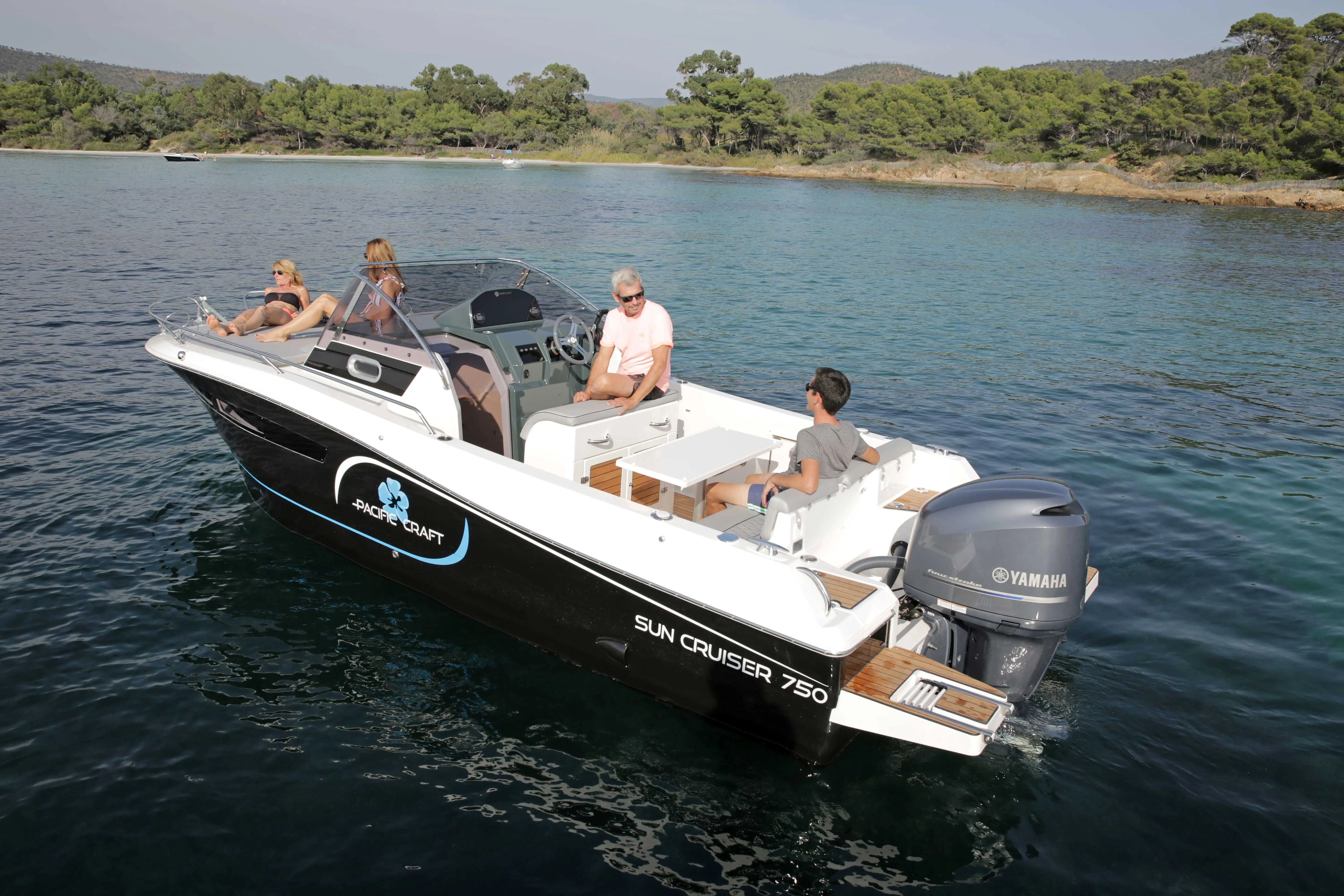 Pacific Craft 750 Open — Bateau à moteur blanc et noir, vu de trois quarts sur une eau calme.