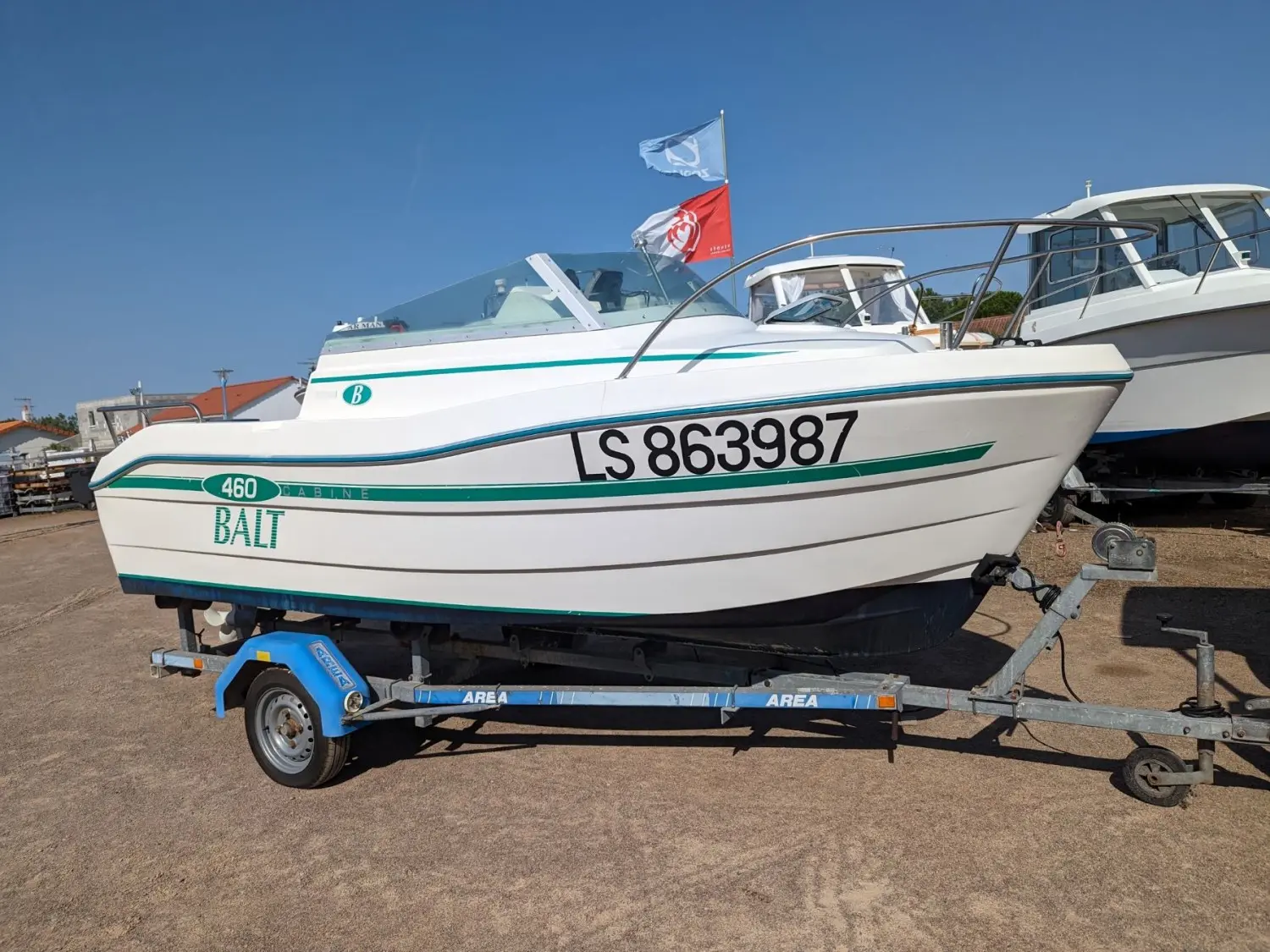 Balt 460 — Bateau à cabine Balt 460 présenté sur sa remorque, vu de profil au sec.