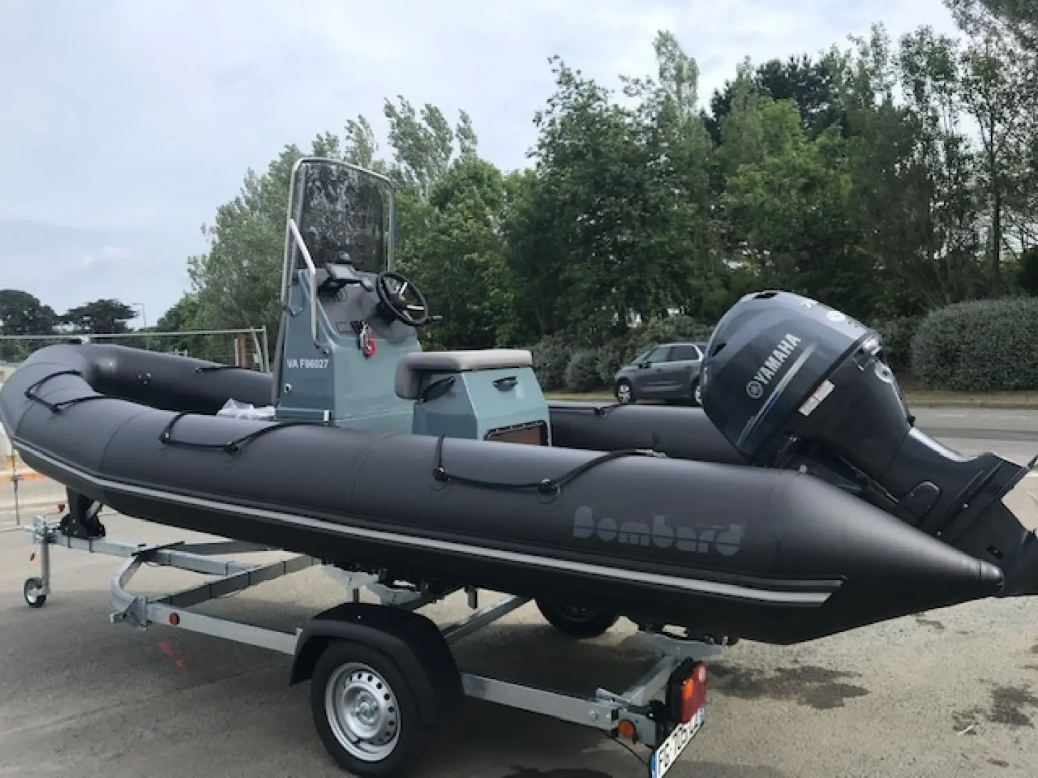 Bombard Explorer 550 — Bateau semi-rigide noir sur remorque, vu de profil avec console centrale et moteur hors-bord.