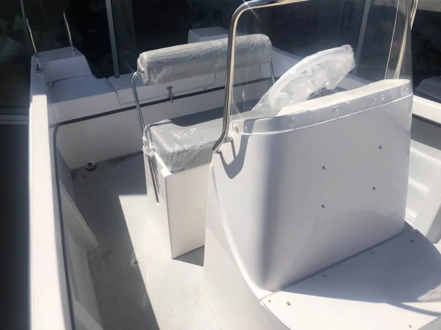 Pescador 550 — Vue rapprochée du poste de pilotage et des sièges protégés d’un bateau.