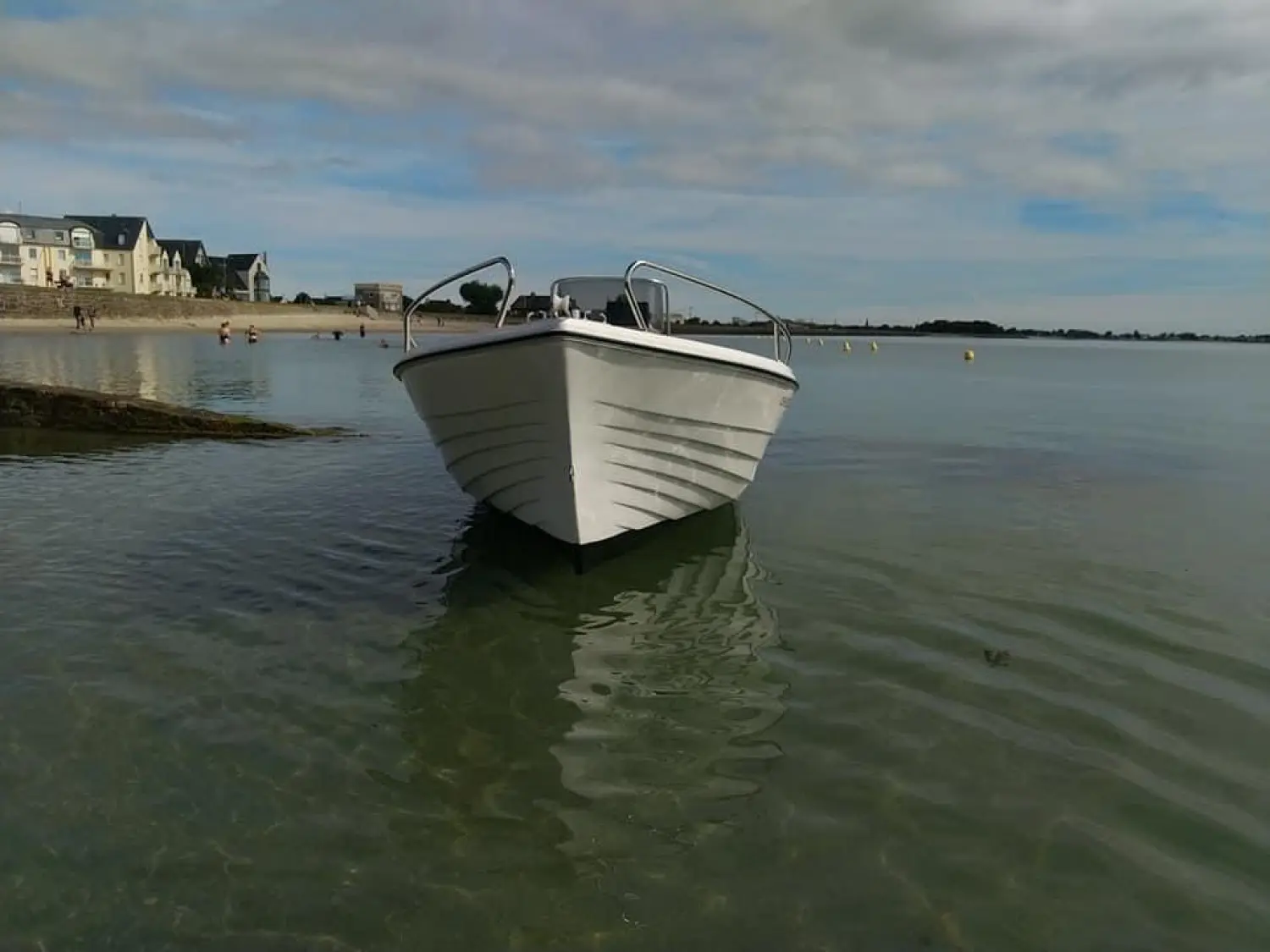 Pescador 550 — Bateau à moteur blanc vu de face, amarré dans une étendue d’eau calme.