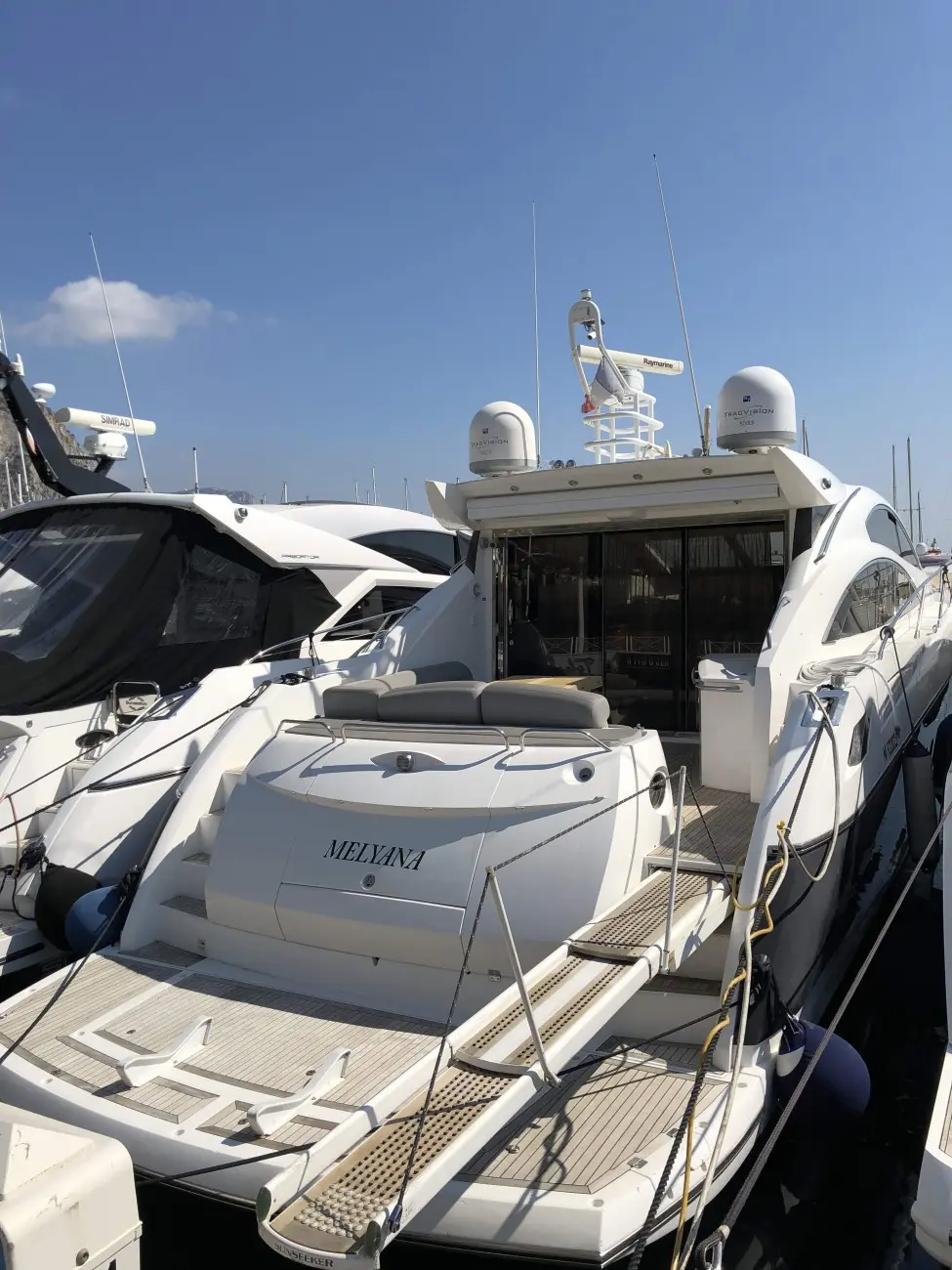 Sunseeker Predator 62 — Vue arrière d’un yacht blanc amarré, avec cockpit et plateforme de bain visibles.