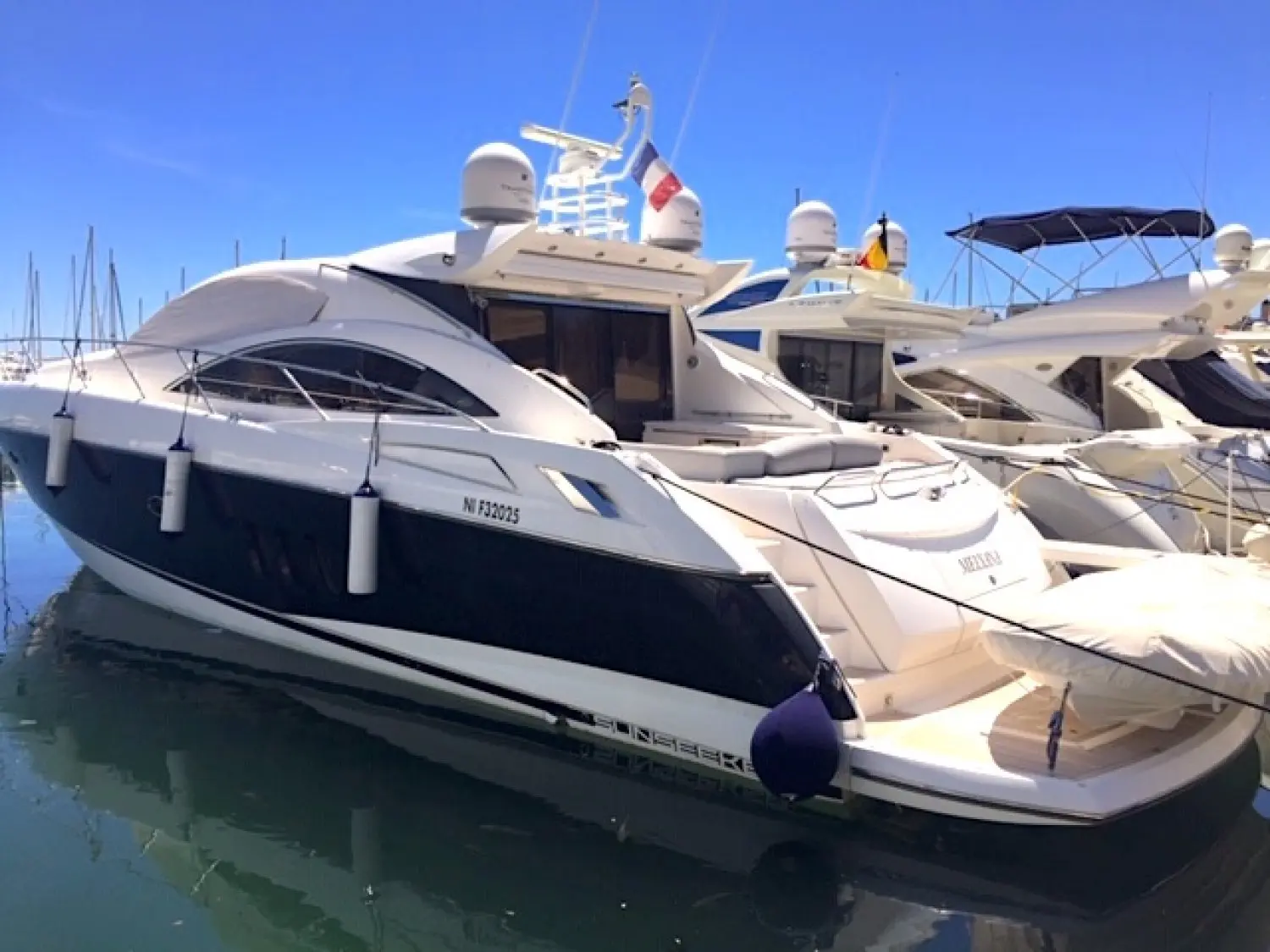Sunseeker Predator 62 — Vedette blanche amarrée dans un port, vue de trois quarts avant.