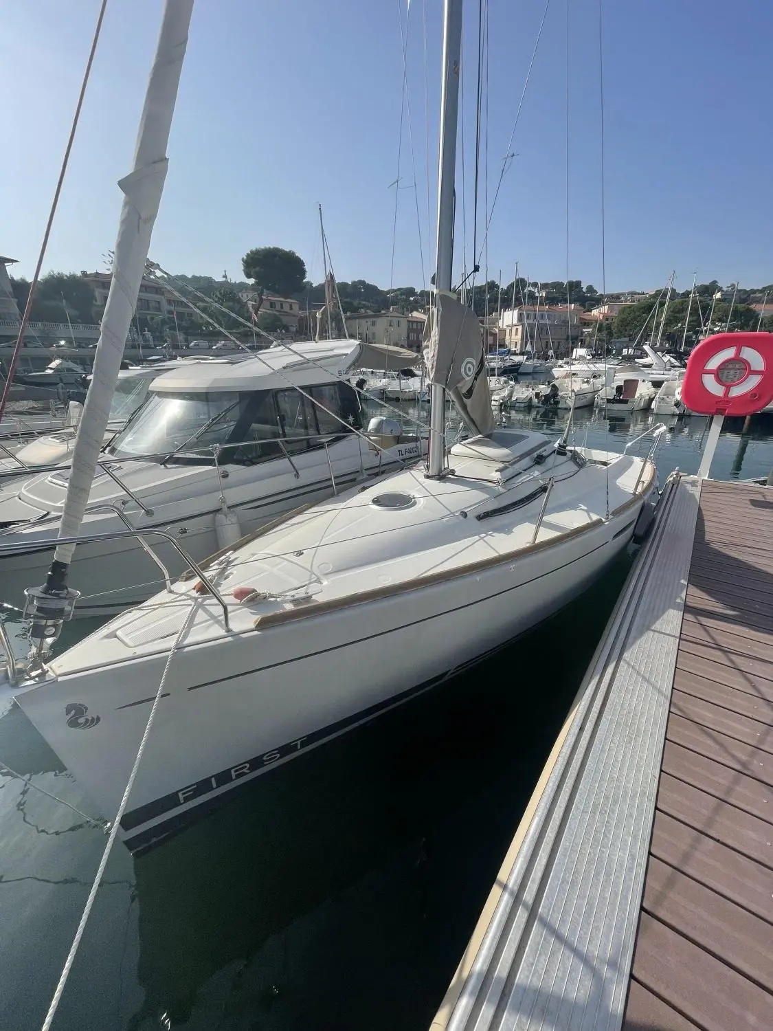 Beneteau First 20 — Voiliers amarrés dans un port, avec un voilier blanc au premier plan.