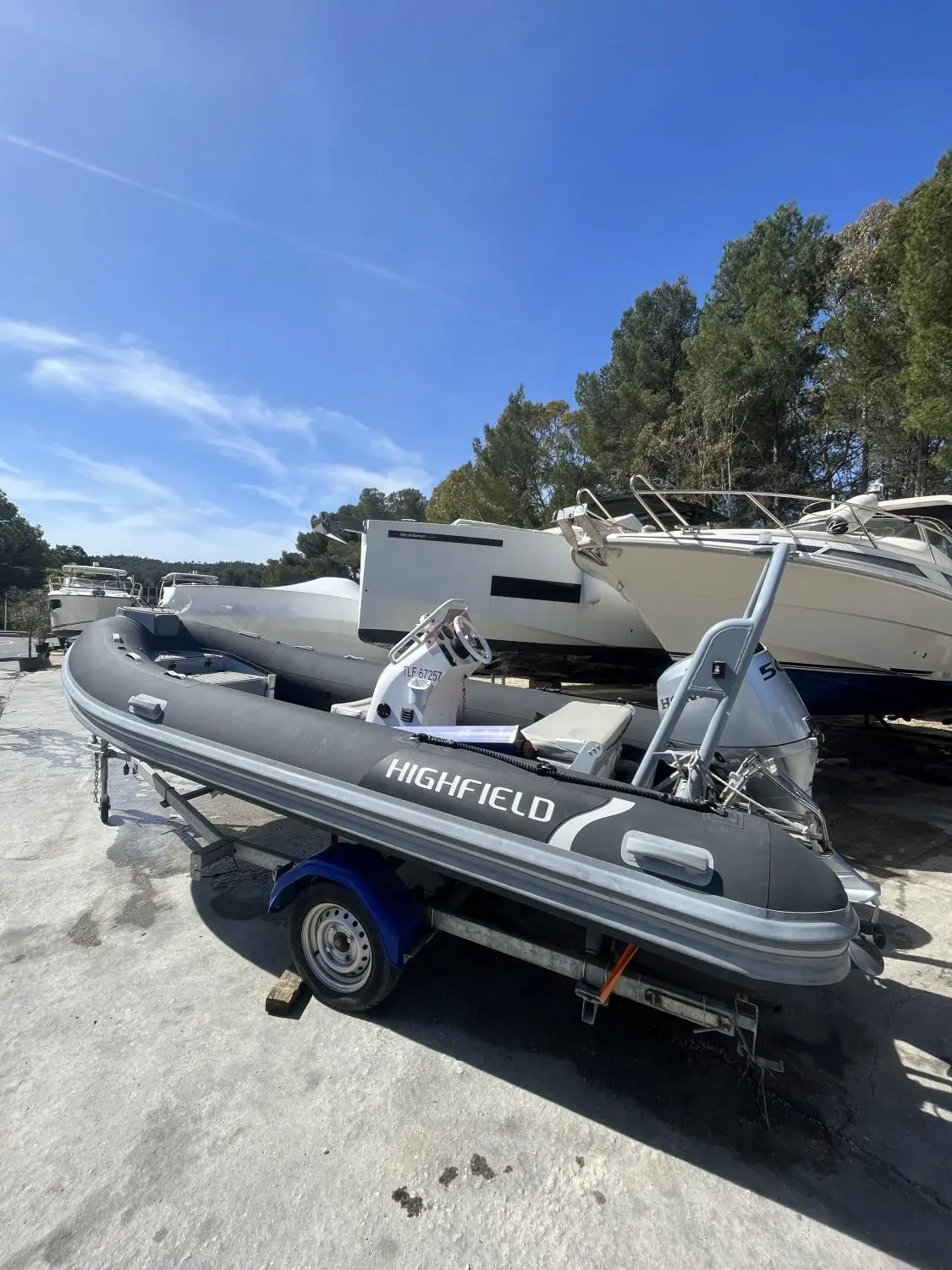 Highfield OM 460 — Semi-rigide gris présenté sur sa remorque dans un parc nautique.