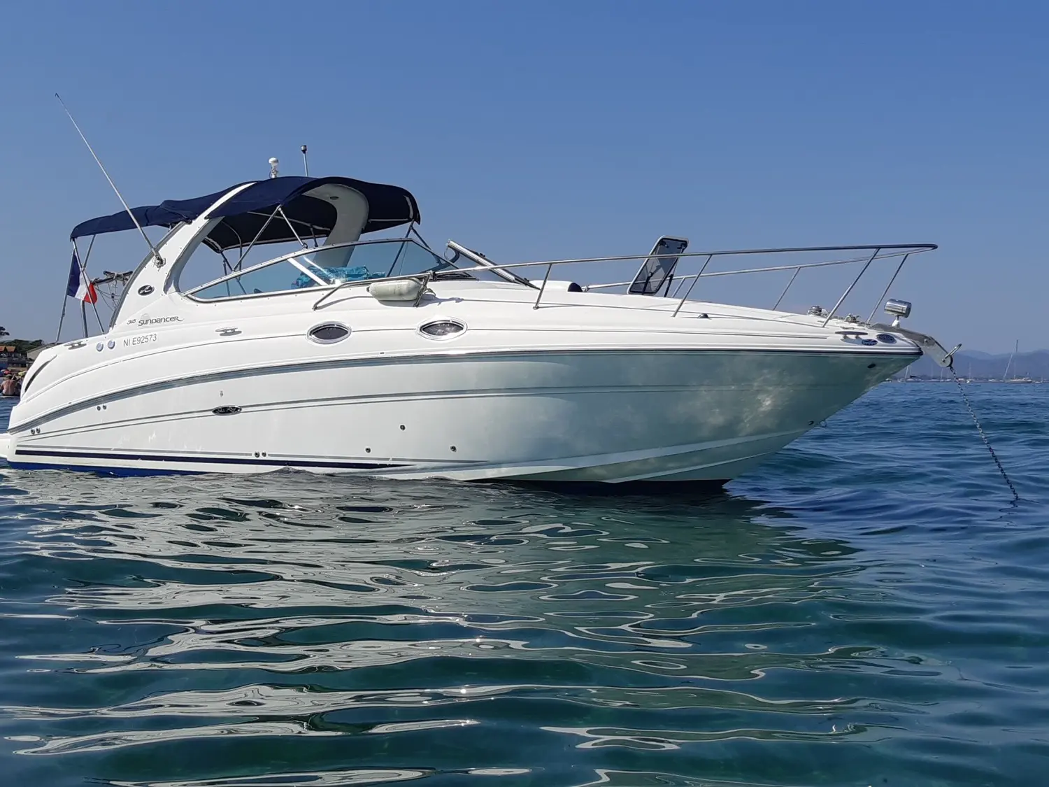 Sea Ray 315 Sundancer — Bateau à moteur blanc vu de trois quarts bâbord sur une eau calme.