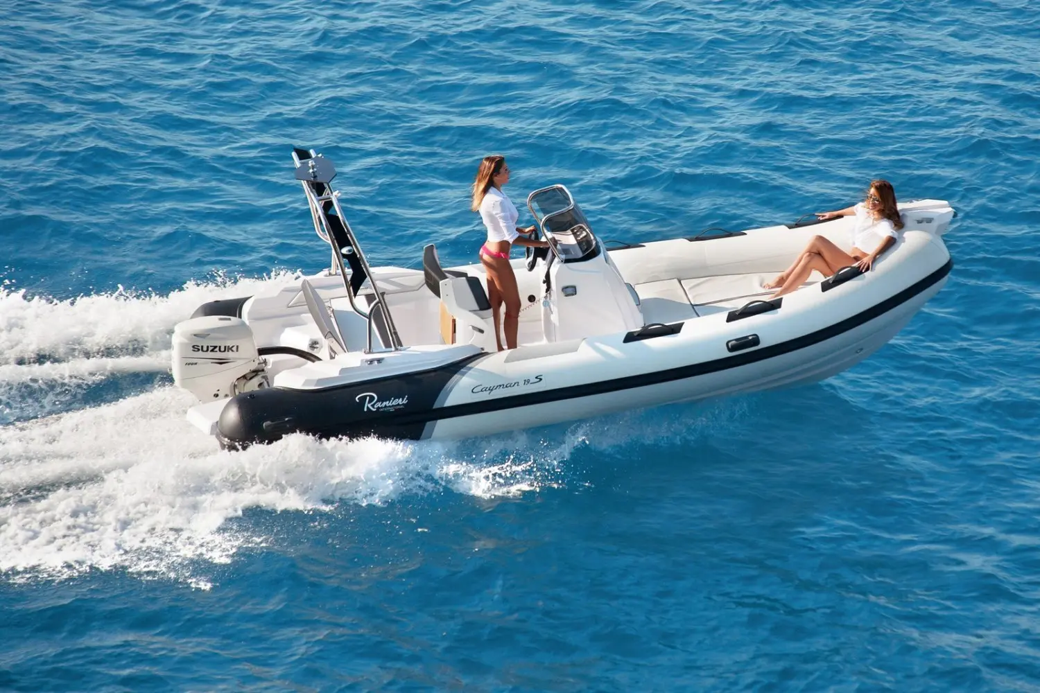 Ranieri Cayman 19 Sport — Bateau pneumatique à moteur hors-bord naviguant en mer avec deux personnes à bord.