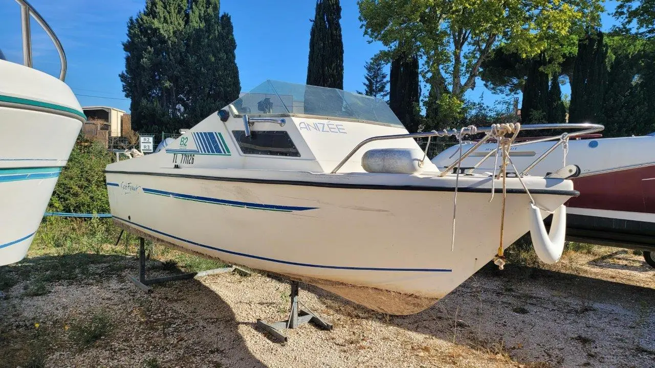 B2 Marine Cap Ferret 500 — Bateau à moteur blanc et bleu présenté à terre sur bers, vu de trois quarts.