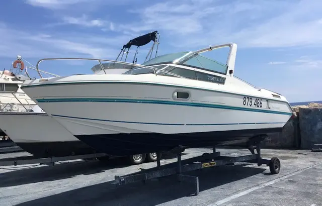 Jeanneau Leader 650 — Bateau à moteur blanc et bleu posé sur une remorque, vu de trois quarts.