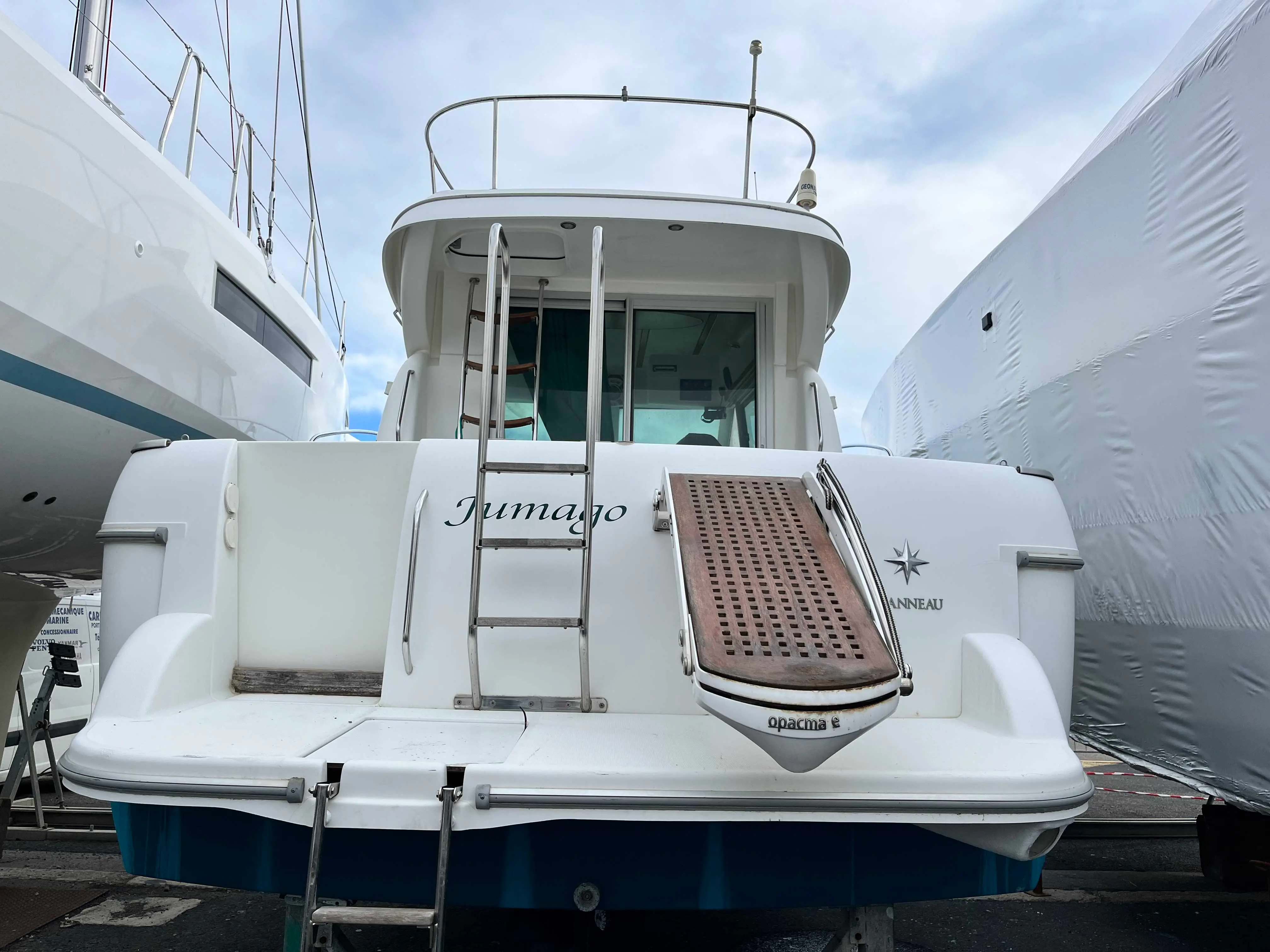 Jeanneau Merry Fisher 925 — Vue arrière d’un bateau blanc avec plateforme de baignade et passerelle.