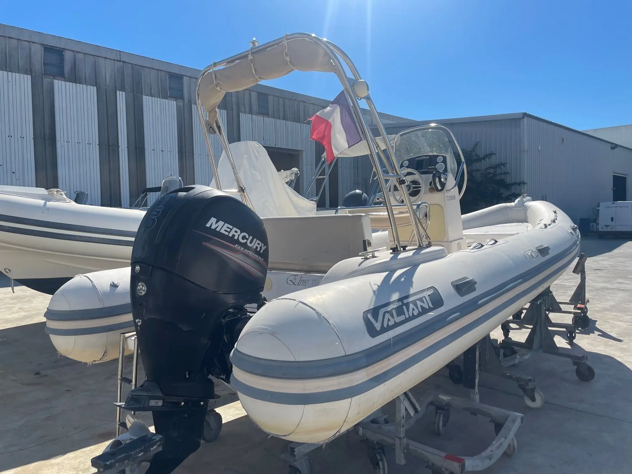 Valiant 630 Classic — Bateau semi-rigide blanc sur remorque, avec moteur hors-bord et arceau.