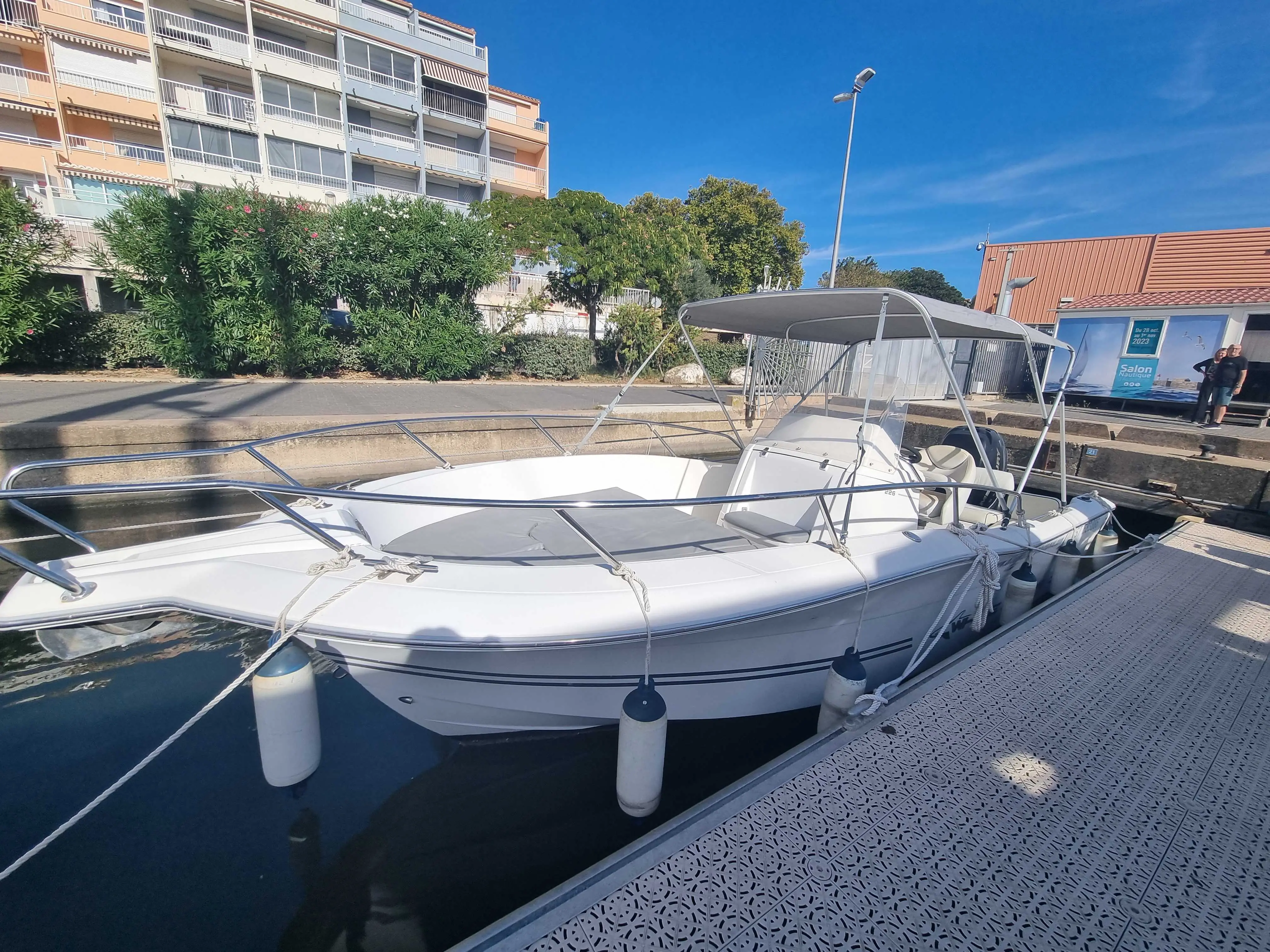 Kelt White Shark 226 — Bateau à moteur blanc amarré au ponton, vu de trois quarts sous un ciel dégagé.