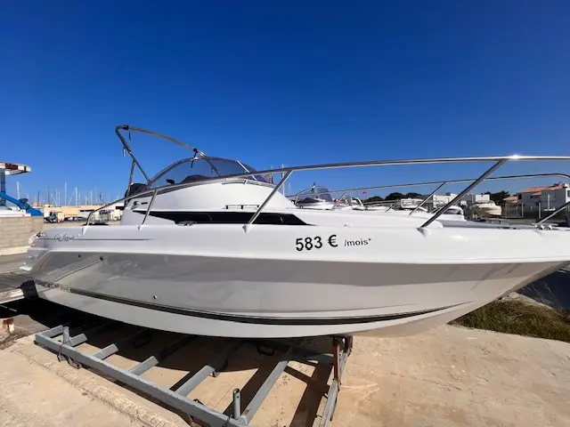 B2 Marine Cap Ferret 752 — Vue latérale d’un bateau blanc sur remorque dans un port ensoleillé.