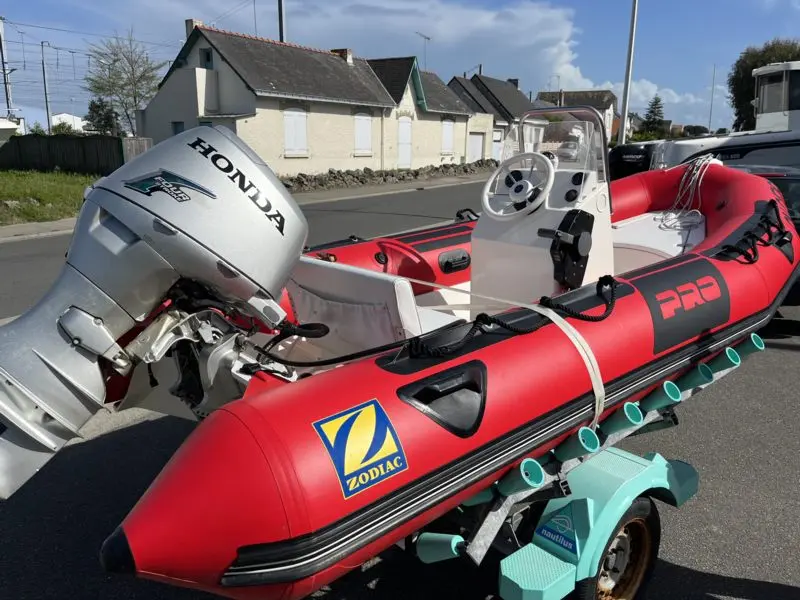 Zodiac Pro 7 Man — Bateau pneumatique rouge équipé d’un moteur hors-bord, photographié sur sa remorque.