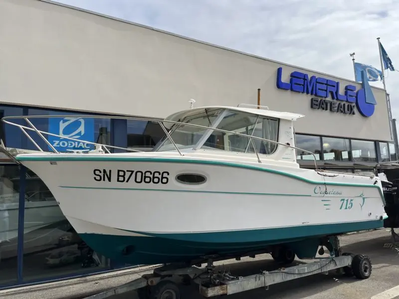 Ocqueteau 715 — Bateau blanc exposé sur remorque devant un bâtiment commercial.