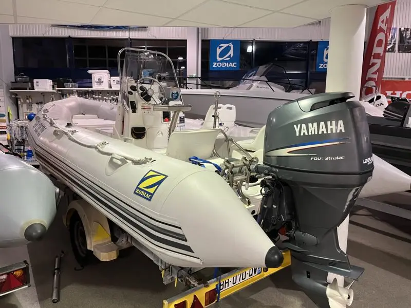 Zodiac Pro Open 550 — Bateau pneumatique blanc exposé sur remorque, vu de trois quarts arrière.