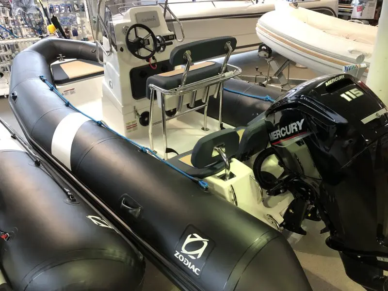 Zodiac Pro Open 550 — Bateau pneumatique présenté en intérieur, avec console centrale et moteur hors-bord.