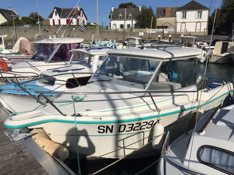 Ocqueteau 540 — Bateau à moteur blanc amarré dans un port, vu de trois quarts avant.