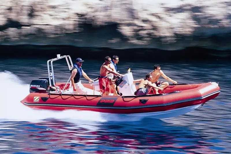Zodiac Pro 15 Man — Bateau pneumatique semi-rigide rouge naviguant avec plusieurs personnes à bord.