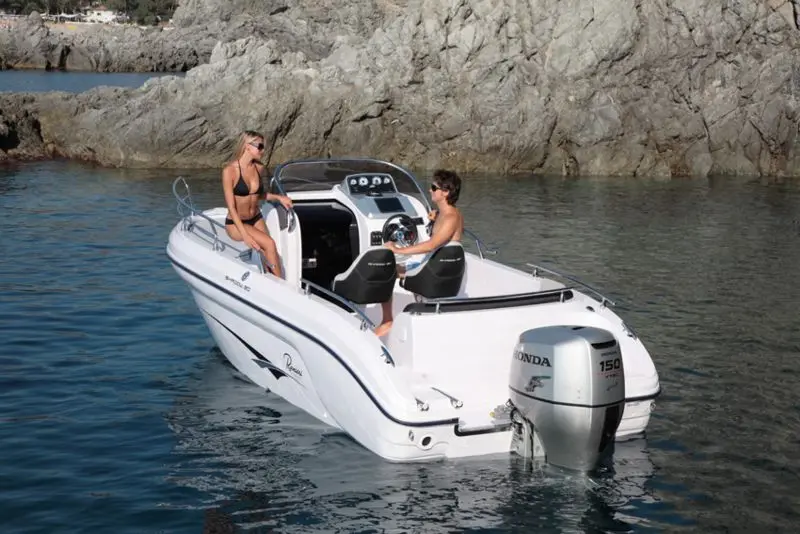 Ranieri Shadow 20 — Bateau à moteur blanc vu de trois-quarts arrière dans une crique rocheuse.