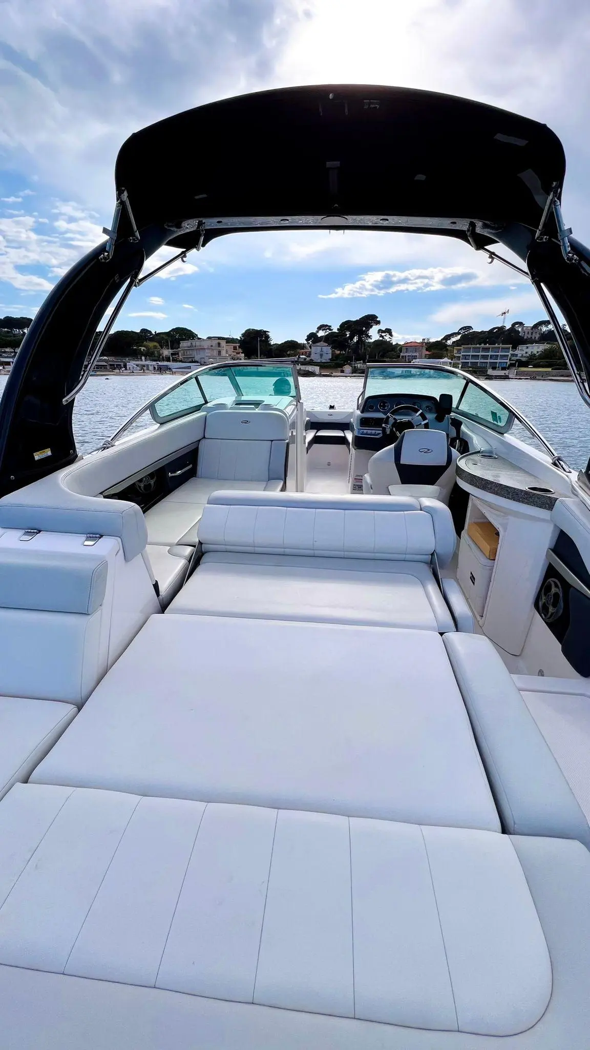 Regal 24 Fastdeck — Vue du cockpit avec sièges, poste de pilotage et taud, face à la marina.