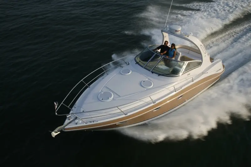 Four Winns Vista 318 — Bateau à moteur blanc et beige naviguant à grande vitesse, vu en plongée.