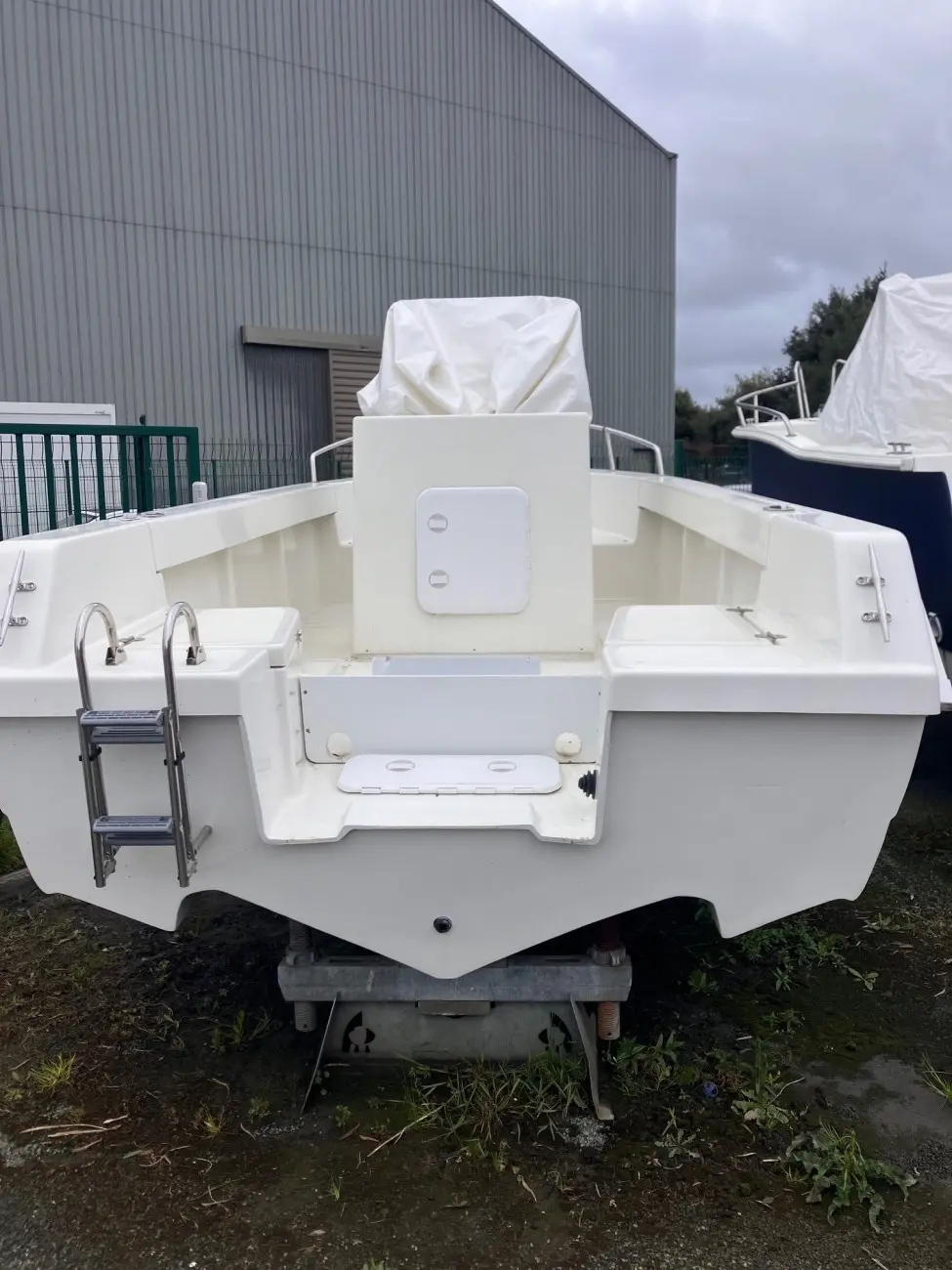 Acroplast Albacore — Vue arrière d’un bateau blanc avec échelle de bain et équipements bâchés.