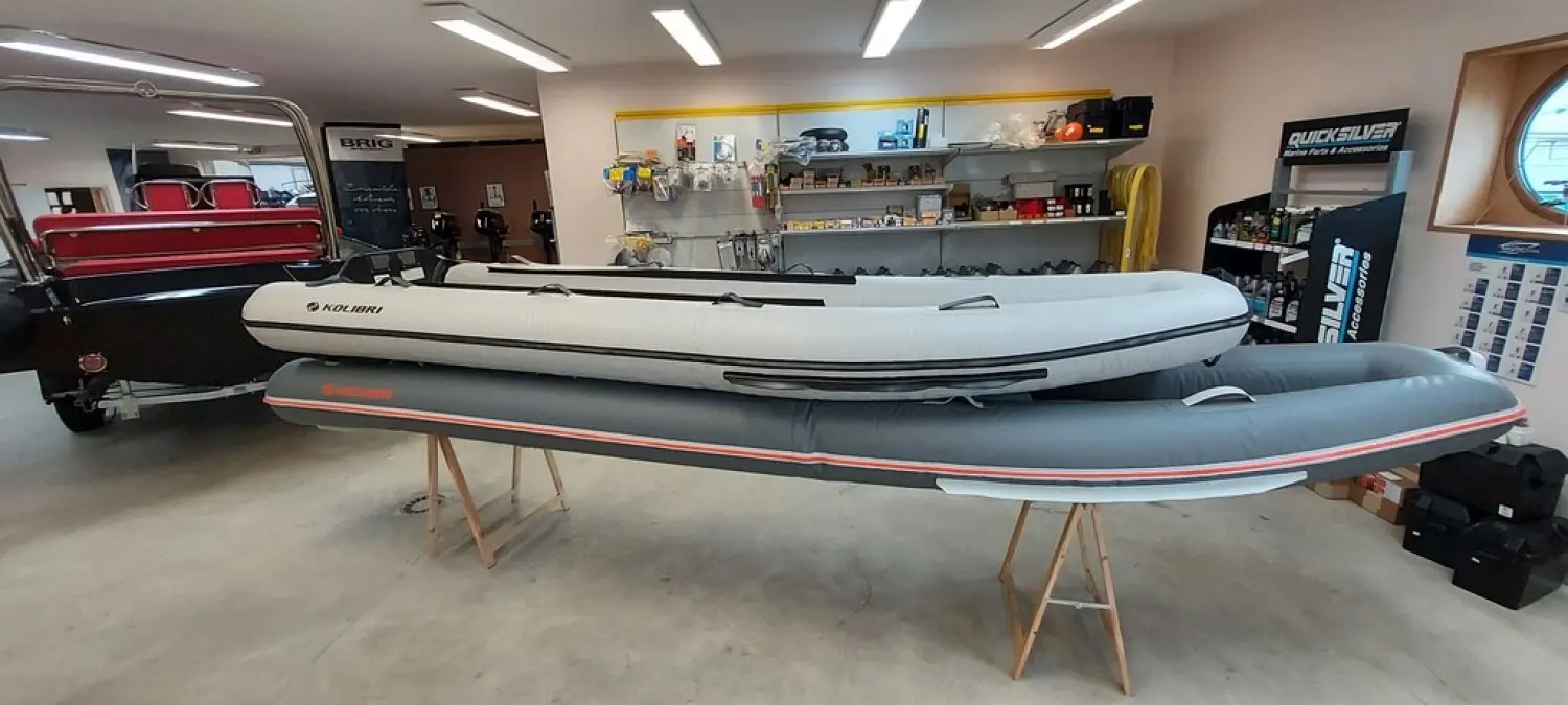 Kolibri Km 390c — Bateau pneumatique gris et blanc présenté sur des tréteaux dans un magasin.