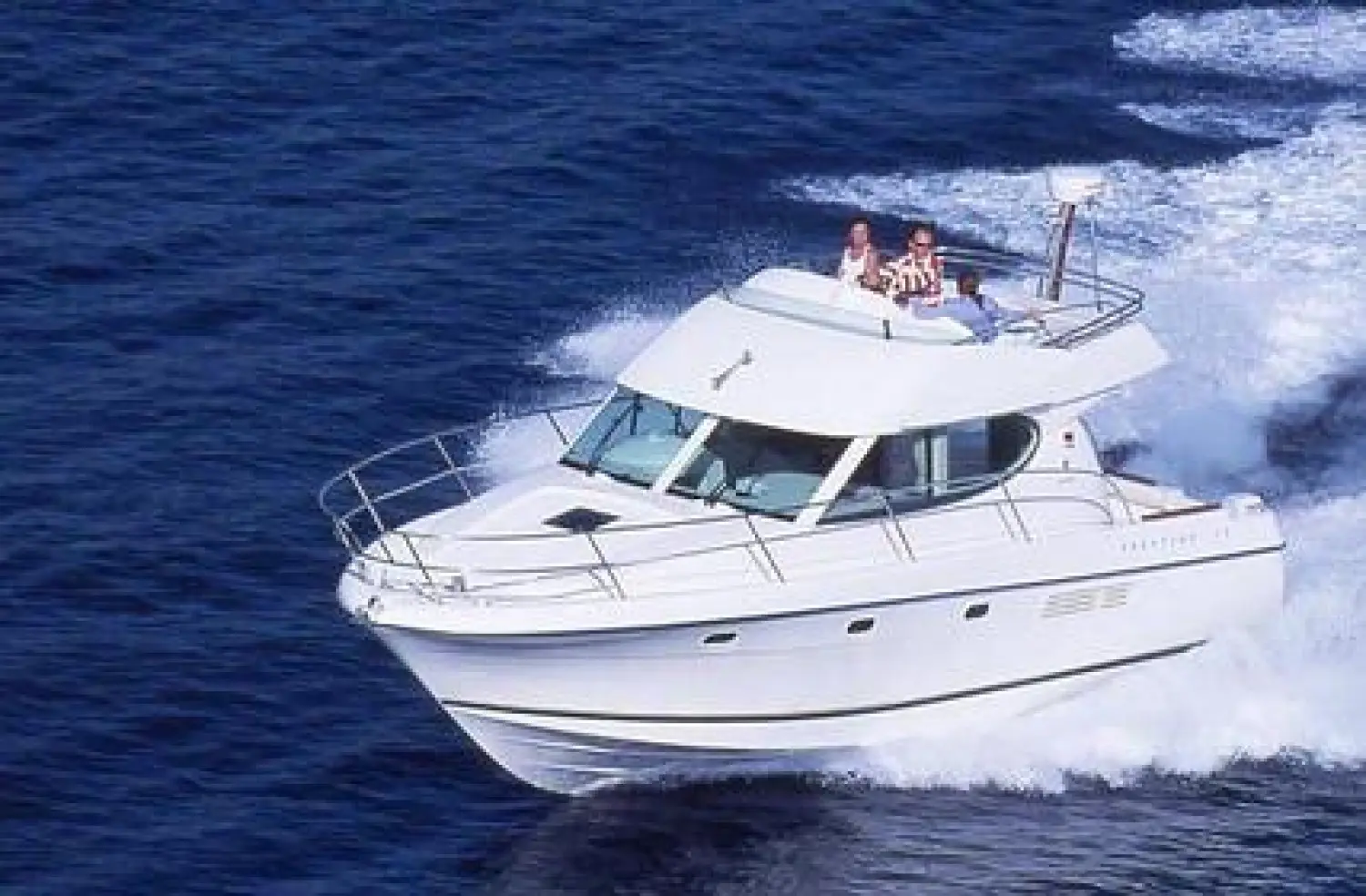 Jeanneau Prestige 32 — Vedette à moteur blanche naviguant à vive allure, vue de trois quarts avant.