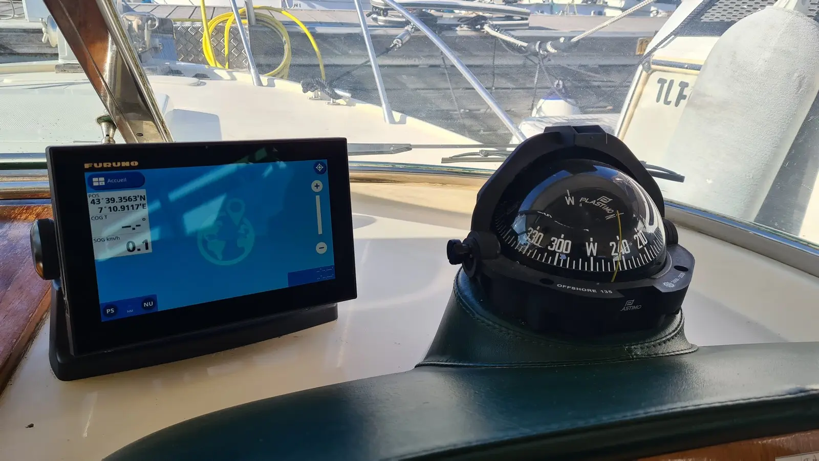 Riva 25 Sport Fisherman — Vue rapprochée du poste de navigation avec écran GPS et compas magnétique.