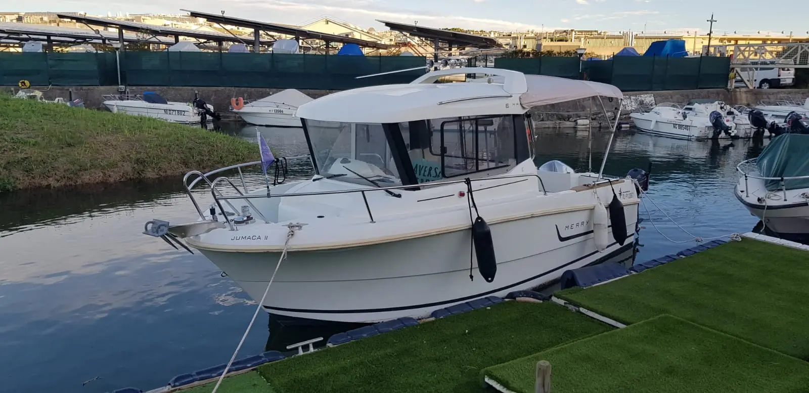 Jeanneau Merry Fisher 6 Marlin — Bateau à moteur blanc amarré dans un port, vu de trois quarts avant bâbord.