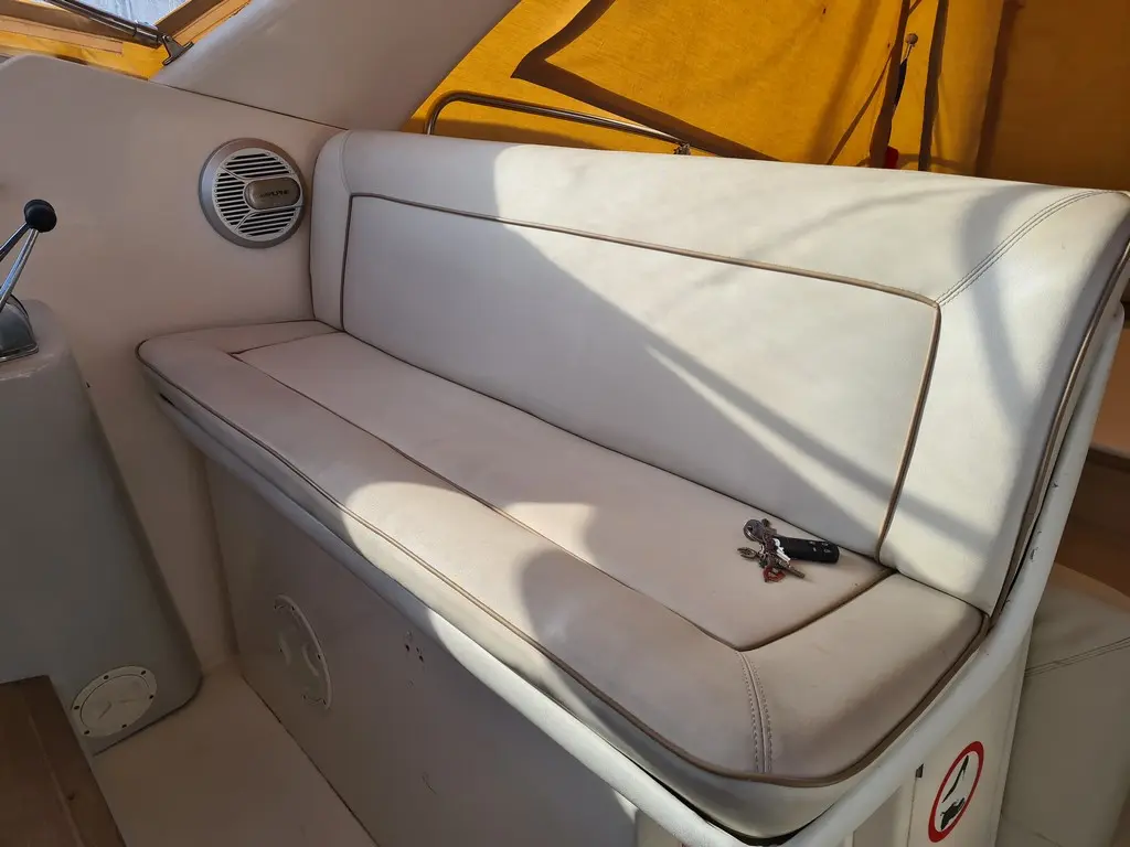Rio 950 Cruiser — Banquette rembourrée blanche dans le cockpit intérieur du bateau.