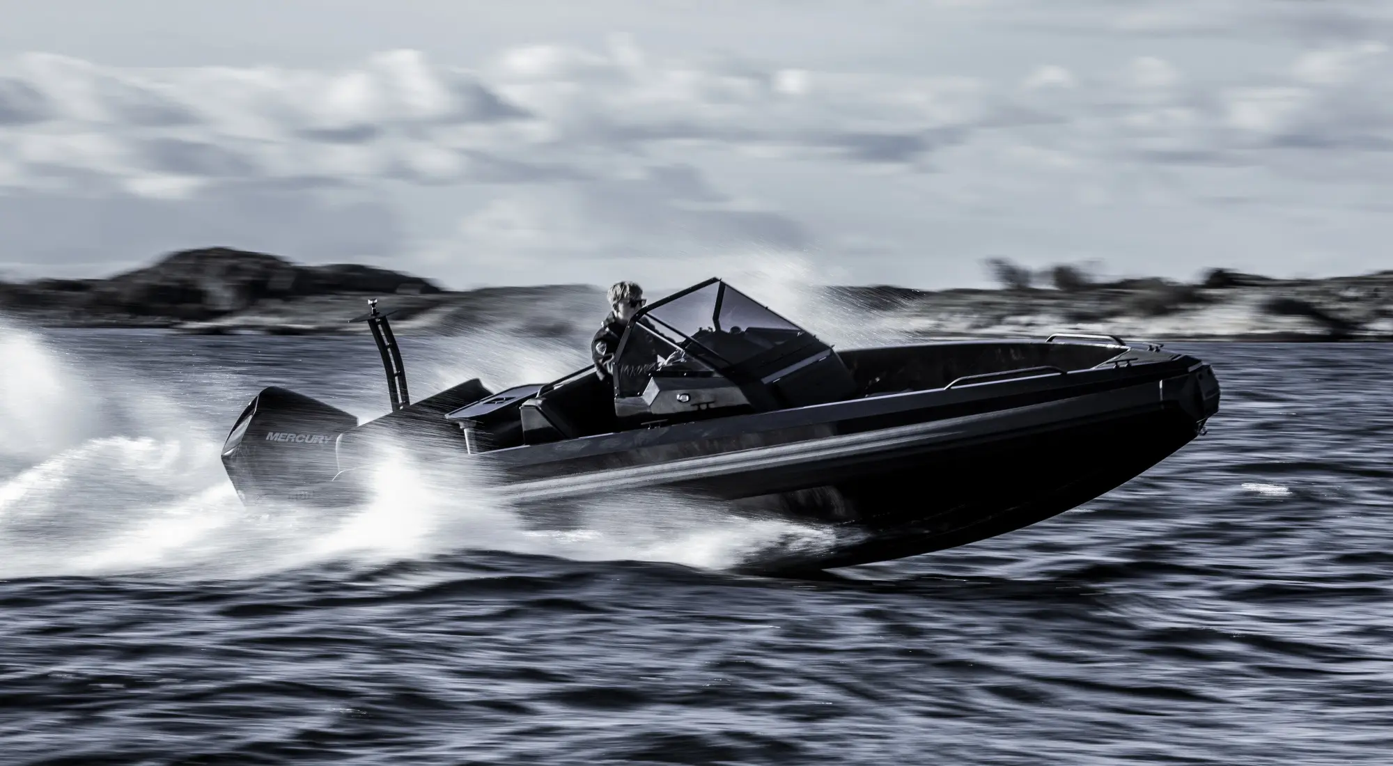 Iron Boats 647 — Bateau à moteur noir naviguant rapidement sur une mer agitée, vu de trois quarts.