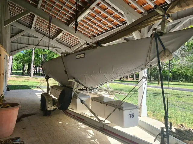 Petticrows Dragon — Bateau à voile sous housse, entreposé dans un abri extérieur.